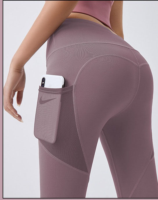 Vrouw in sportlegging met telefoon in zijvak