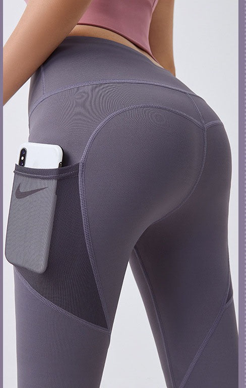 Vrouw in sportlegging met telefoon in zijvak